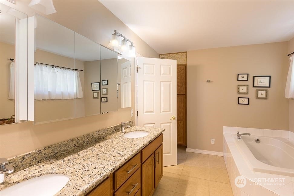 50 Henkes Road Sequim, WA 98382 - Photo 20 of 40 a spacious bathroom with a granite countertop tub sink and mirror