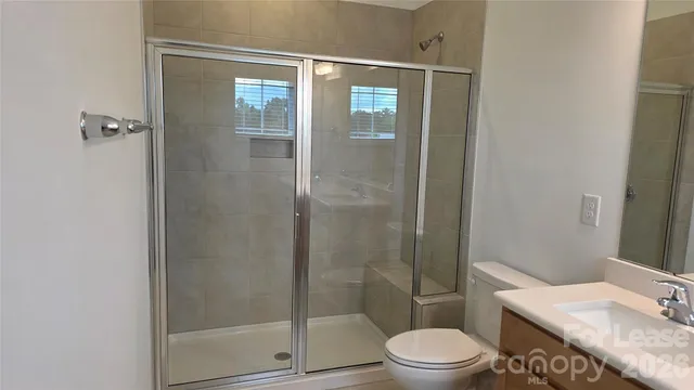 a bathroom with a granite countertop toilet a sink and shower