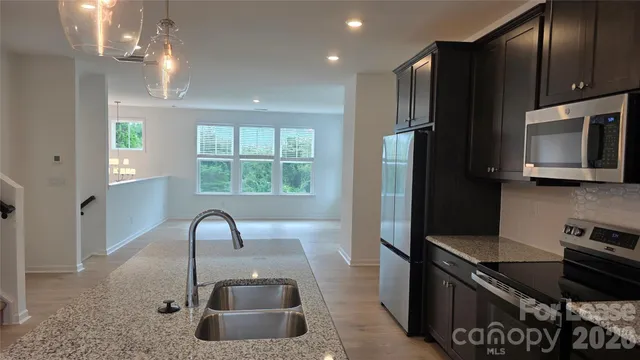 a kitchen with a sink a refrigerator and a stove top oven