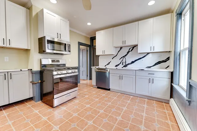 a kitchen with stainless steel appliances a stove microwave and cabinets