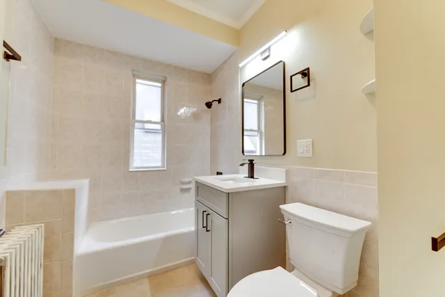 a bathroom with a sink toilet vanity and bathtub