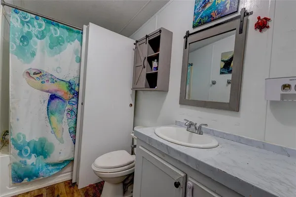 a bathroom with a granite countertop toilet sink and mirror