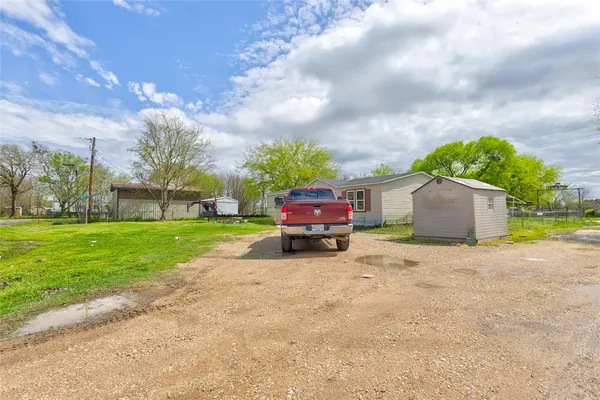 a car parked in front of a house with a big yard
