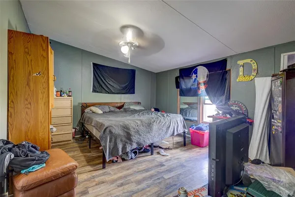 a bedroom with bed and wooden floor