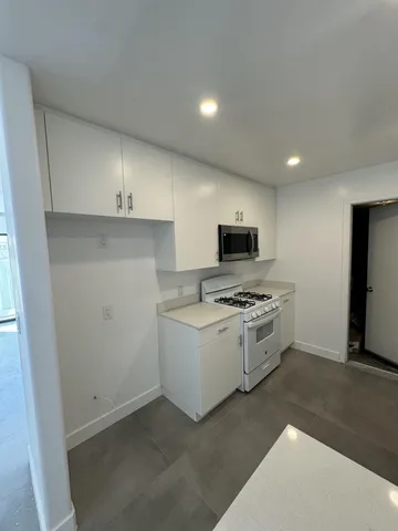 a kitchen with stainless steel appliances granite countertop a stove a sink and a refrigerator