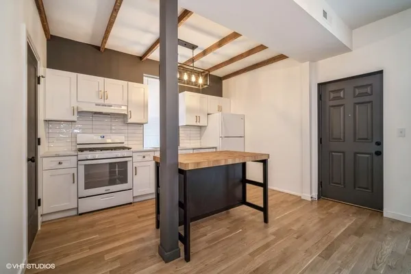 a view of kitchen with sink and refrigerator