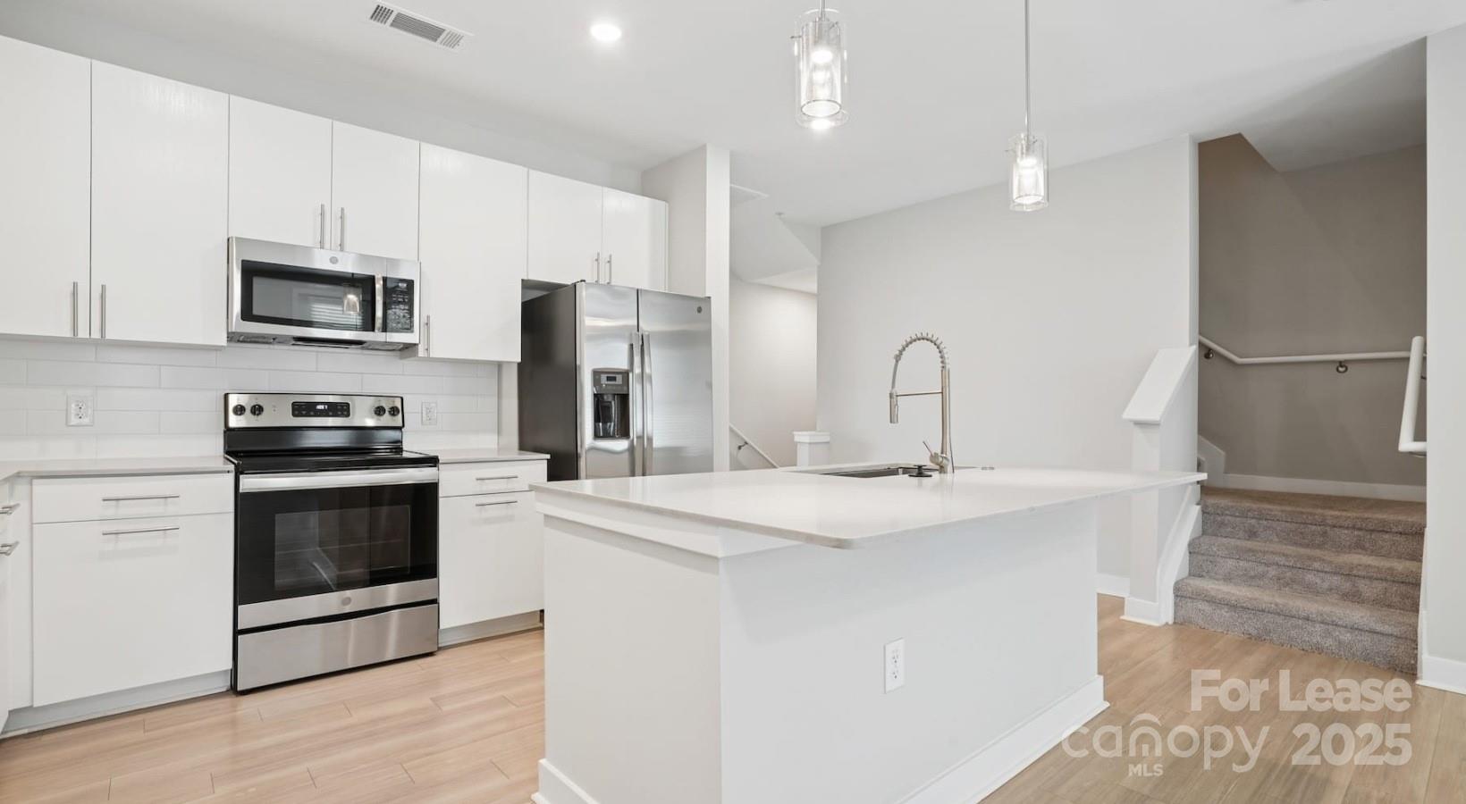 4010 Waiting Street, Unit C3 Matthews, NC 28105 - Photo 3 of 36 a kitchen with stainless steel appliances a stove sink and microwave