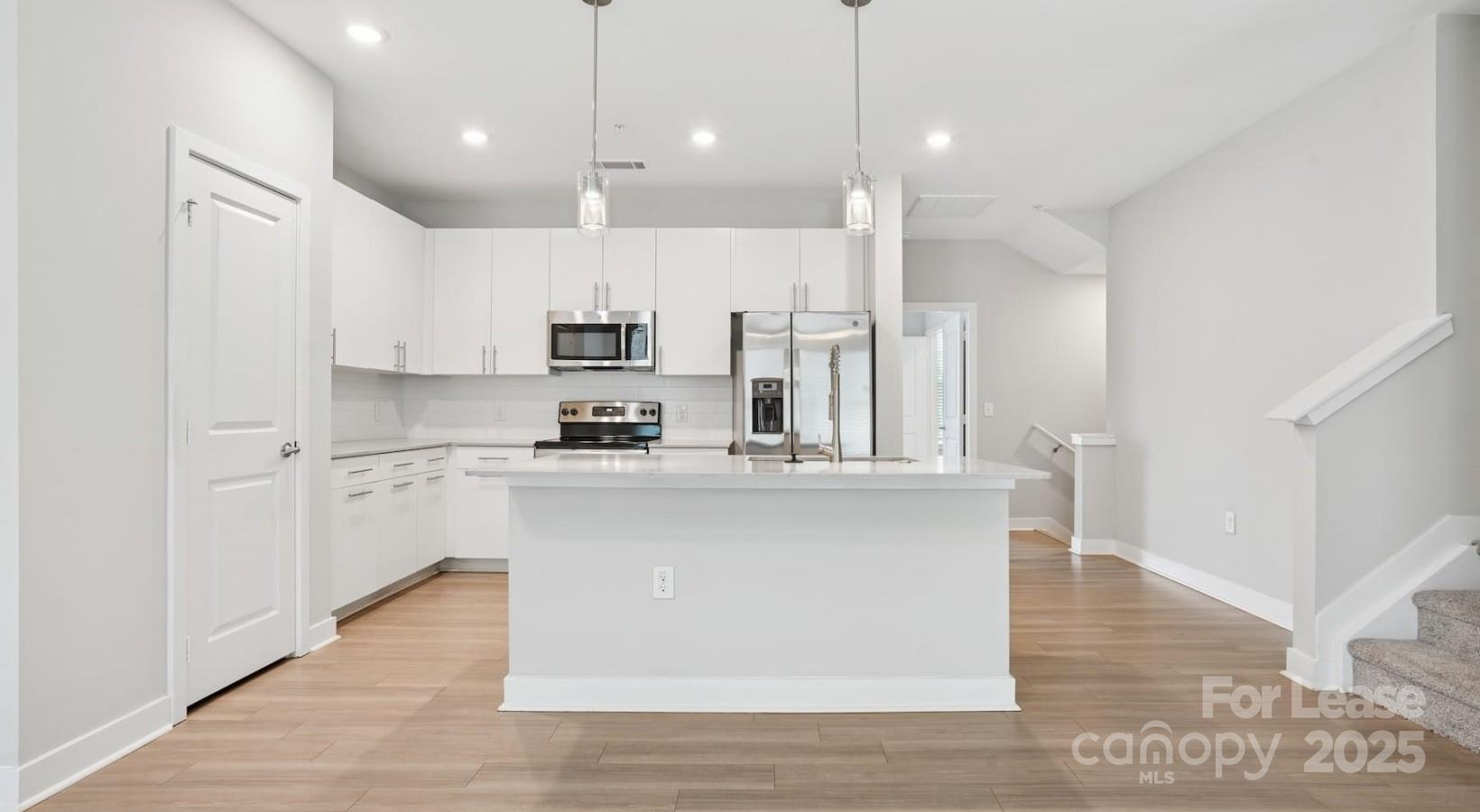 4010 Waiting Street, Unit C3 Matthews, NC 28105 - Photo 6 of 36 a large white kitchen with lots of counter space a sink appliances and cabinets