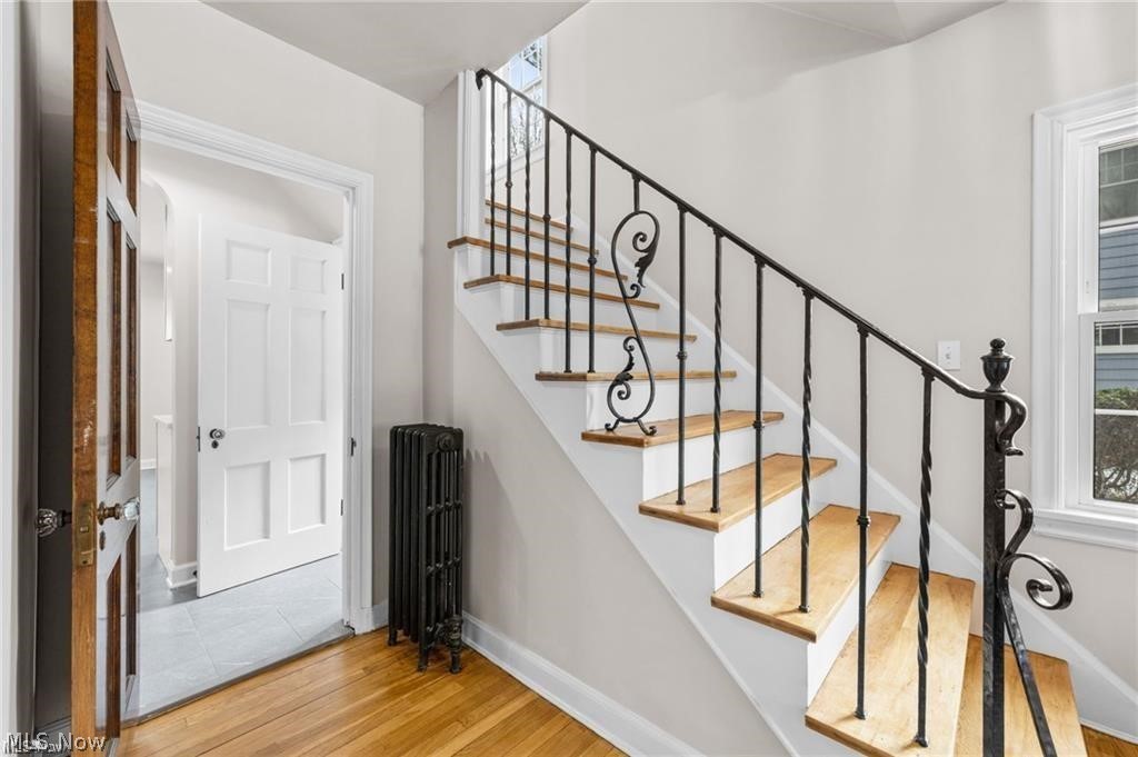 3145 Huntington Road Shaker Heights, OH 44120 - Photo 15 of 28 Staircase featuring wood treads, white risers, and wrought iron balusters with decorative scrollwork