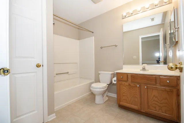 a bathroom with a double vanity sink toilet mirror and bathtub