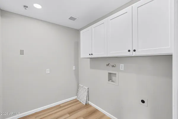 a front view of a house with a yard and potted plants