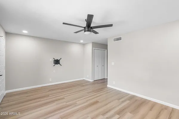 a view of a big room with wooden floor and a ceiling fan