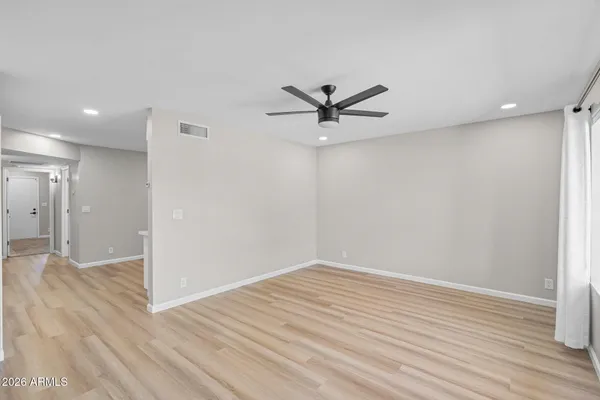 a kitchen with stainless steel appliances granite countertop a stove a refrigerator a sink a dining table and chairs with wooden floor