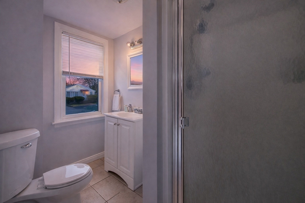 23 Whitehall Street Providence, RI 02909 - Photo 4 of 7 a bathroom with a granite countertop toilet a sink and a mirror