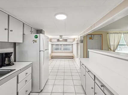 a kitchen with granite countertop a refrigerator and a stove top oven