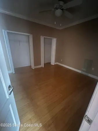 en empty room with windows and ceiling fan