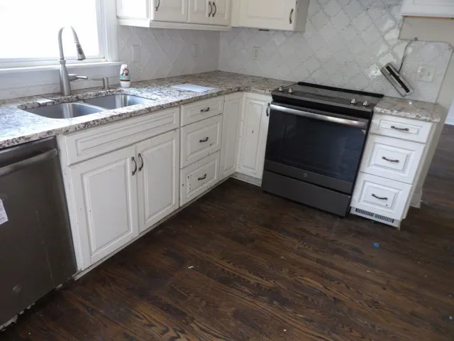 a kitchen with appliances a sink and cabinets