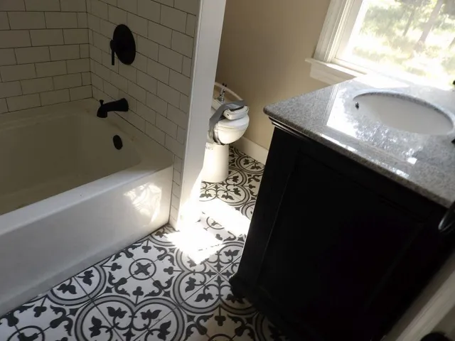 a bathroom with a granite countertop sink a toilet and shower