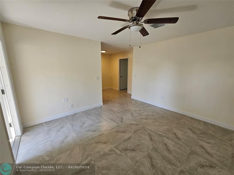 an empty room with a ceiling fan and carpet