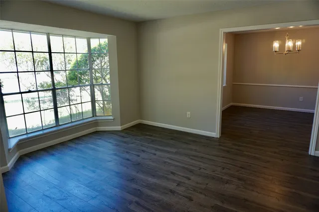 a view of a room with wooden floor and a window