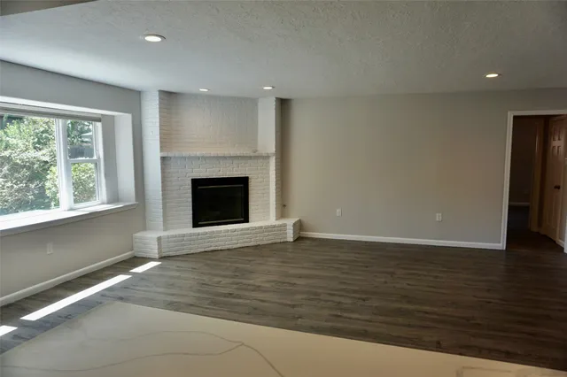 a kitchen with stainless steel appliances wooden floors and white walls