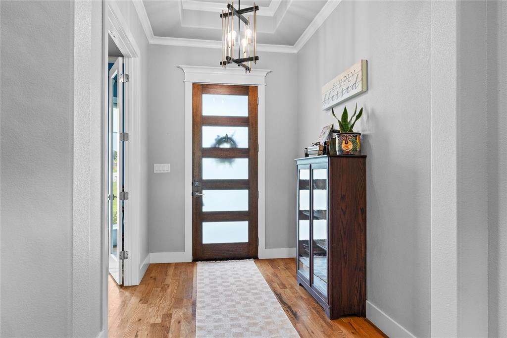 1024 Henry Way Springtown, TX 76082 - Photo 6 of 29 Entryway featuring a wood-panel door with multiple frosted glass panels, wood-finish flooring, and a coffered ceiling