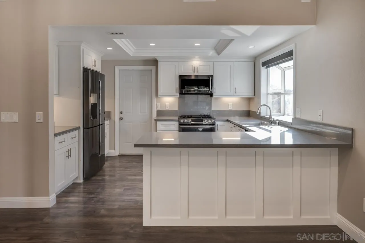 10224 Pebble Beach Drive Santee, CA 92071 - Photo 12 of 30 a kitchen with stainless steel appliances kitchen island granite countertop a refrigerator and a stove top oven