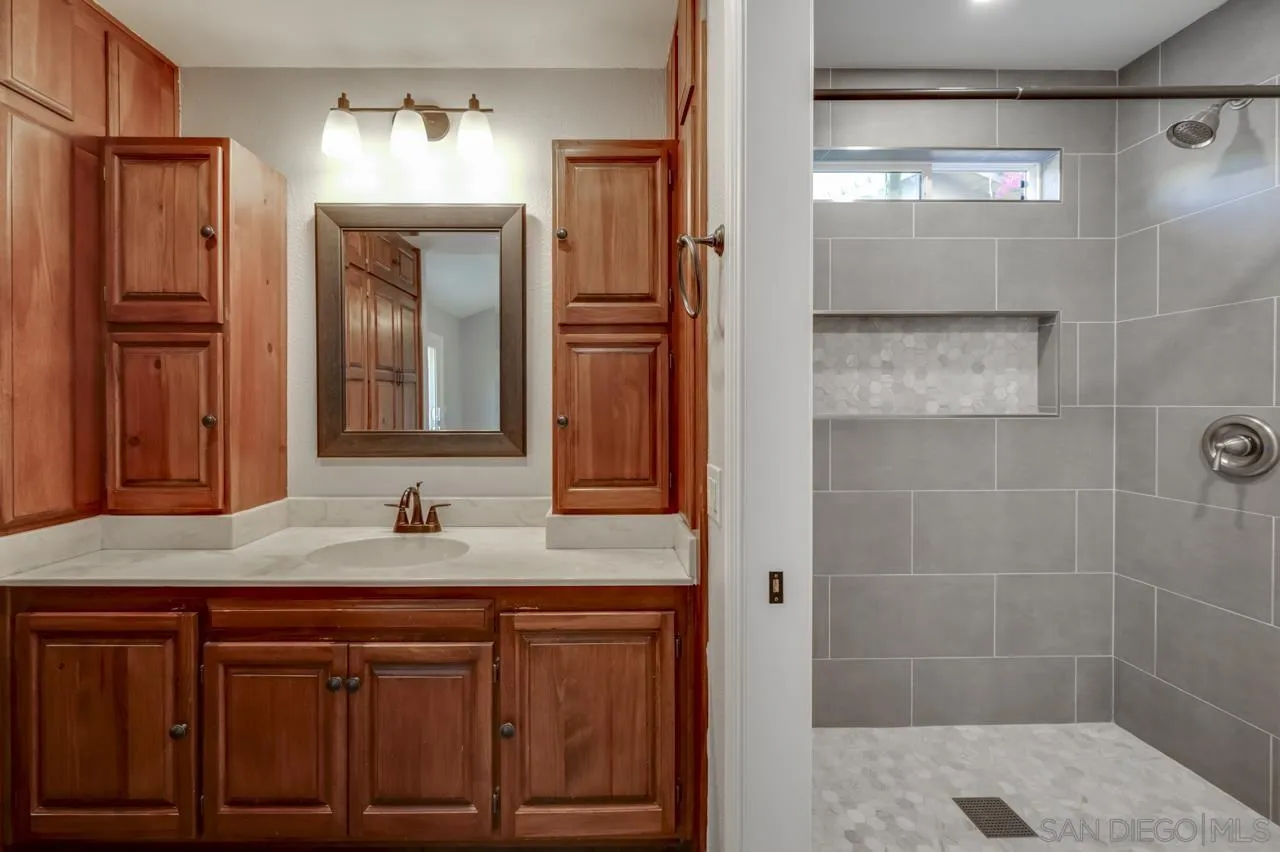 10224 Pebble Beach Drive Santee, CA 92071 - Photo 18 of 30 a bathroom with a shower sink and mirror