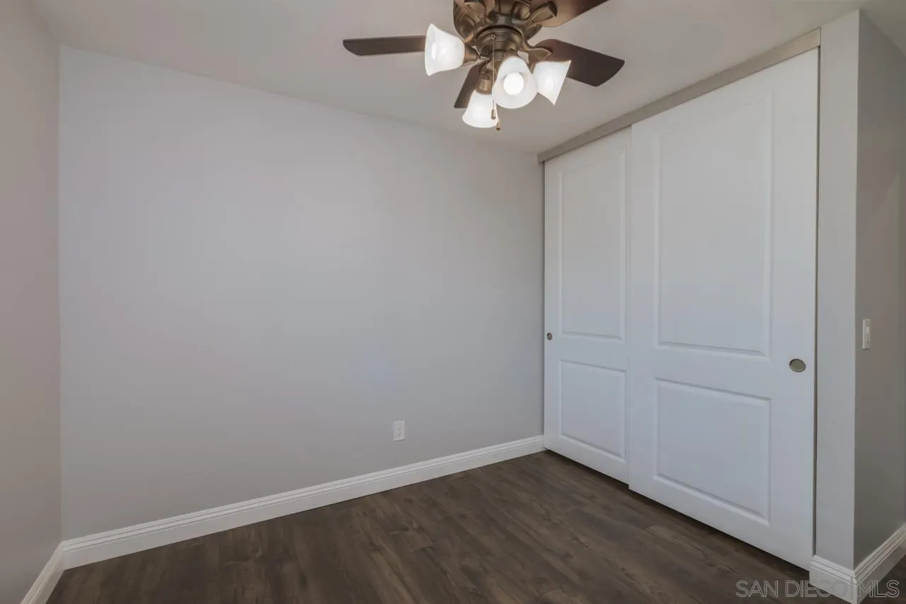 10224 Pebble Beach Drive Santee, CA 92071 - Photo 23 of 30 an empty room with a chandelier fan and wooden floor