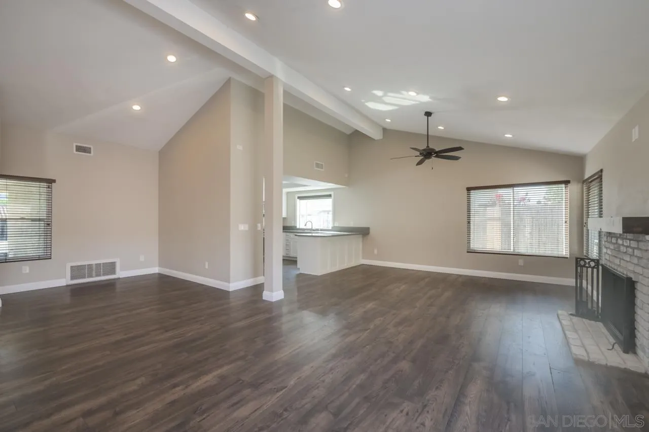 10224 Pebble Beach Drive Santee, CA 92071 - Photo 7 of 30 an empty room with wooden floor fireplace and windows