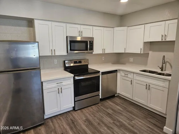 a kitchen with white cabinets stainless steel appliances and sink