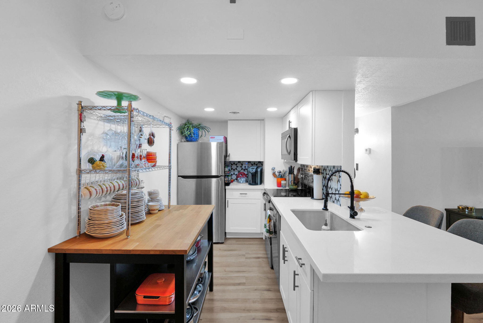 3416 North 44th Street, Unit 69 Phoenix, AZ 85018 - Photo 11 of 19 a kitchen that has a lot of cabinets a sink and wooden floor