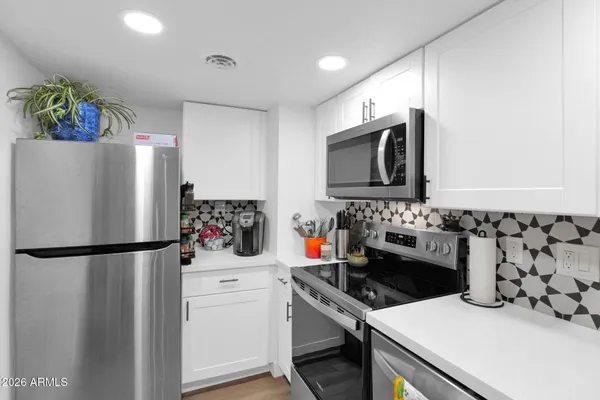a kitchen with a refrigerator and a stove top oven