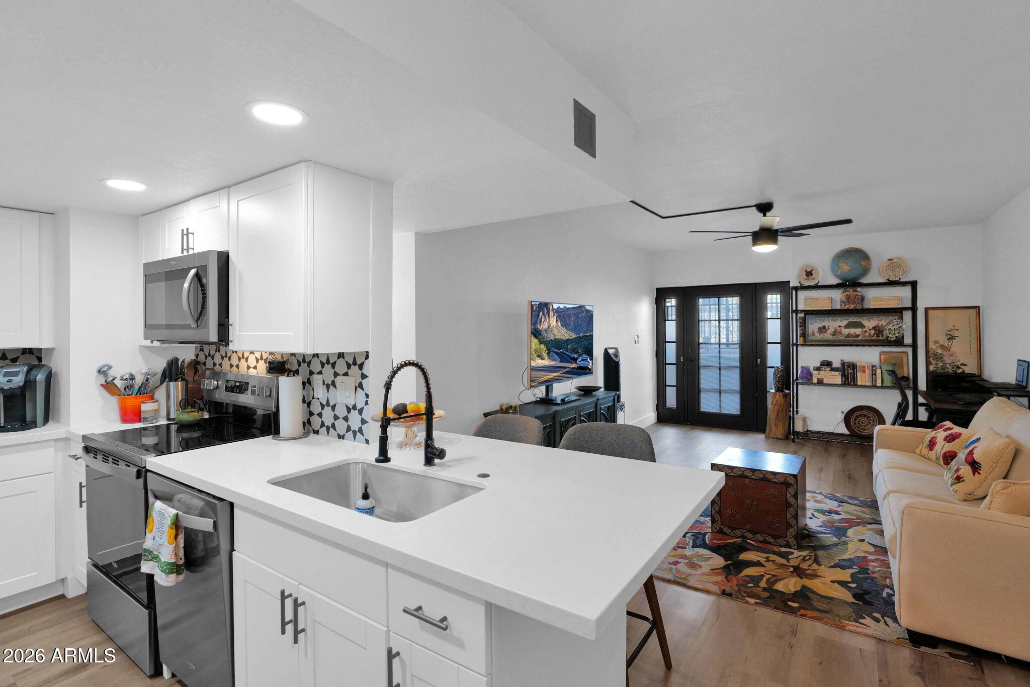 3416 North 44th Street, Unit 69 Phoenix, AZ 85018 - Photo 3 of 19 a kitchen with a sink dishwasher a stove and a dining table with wooden floor