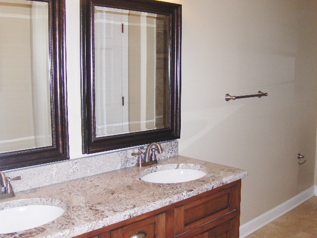 4660 Arkwright Road Macon, GA 31210 - Photo 17 of 32 a bathroom with a granite countertop sink and a mirror