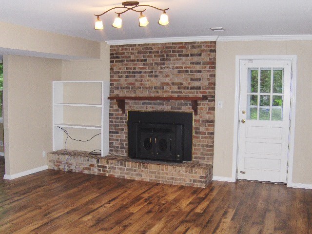 4660 Arkwright Road Macon, GA 31210 - Photo 22 of 32 an empty room with wooden floor a fireplace and window