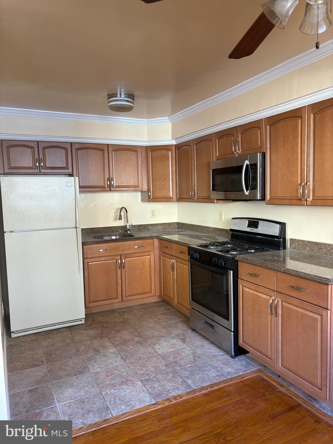 7044 Eastern Avenue Northwest Washington, DC 20012 - Photo 7 of 18 a kitchen with granite countertop a refrigerator stove top oven and sink