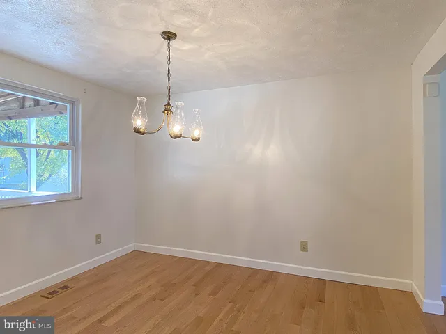 a white toilet sitting next to a white wall