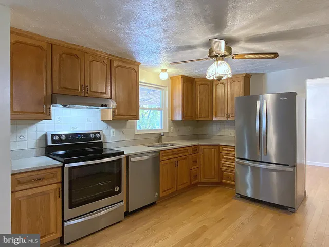 a view of an empty room with wooden floor and closet