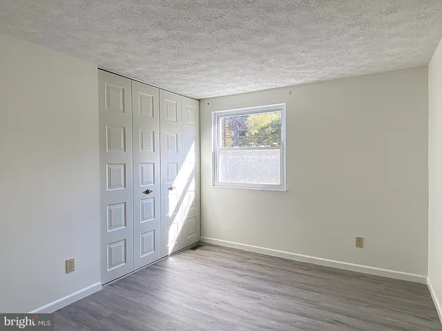 a front view of a house with a garden and trees
