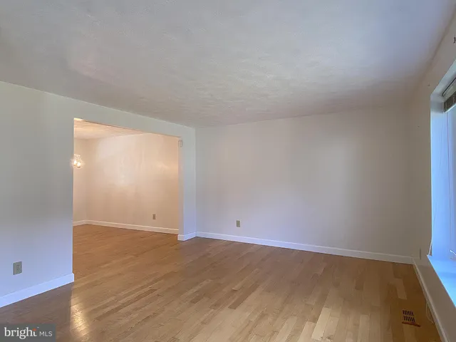 a view of a room with wooden floor chandelier and window