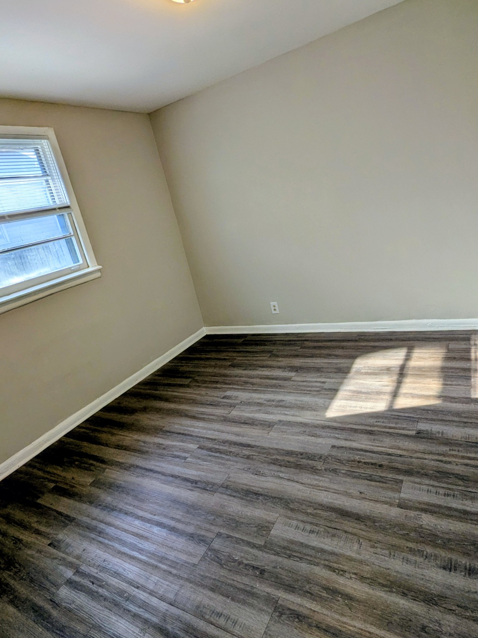 118 Rains Avenue, Unit 2 Nashville, TN 37203 - Photo 5 of 6 a view of an empty room with wooden floor and a window