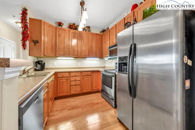 a kitchen with stainless steel appliances granite countertop a sink a stove and a refrigerator