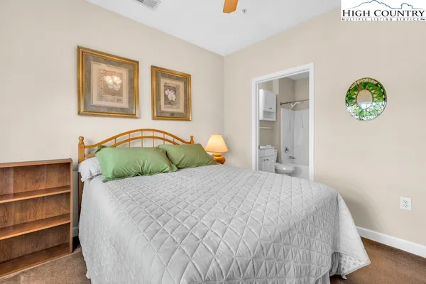 a bedroom with a bed and painting on the wall