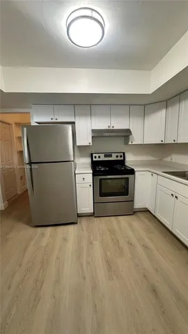 a kitchen with a refrigerator and a stove