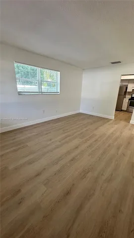 a view of a livingroom with wooden floor and a window