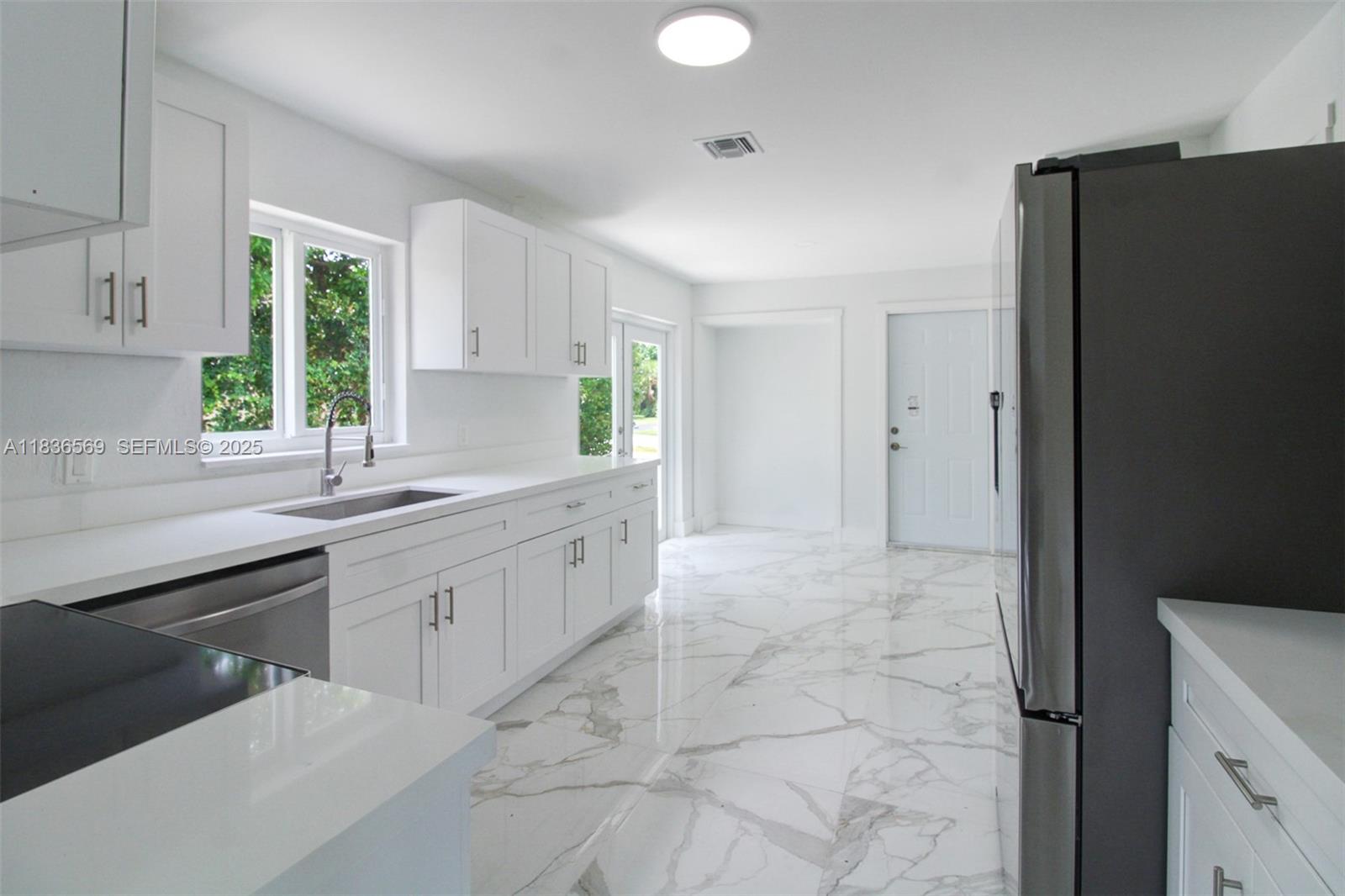 4808 Mango Drive Tamarac, FL 33319 - Photo 18 of 36 a kitchen with granite countertop a refrigerator and a sink