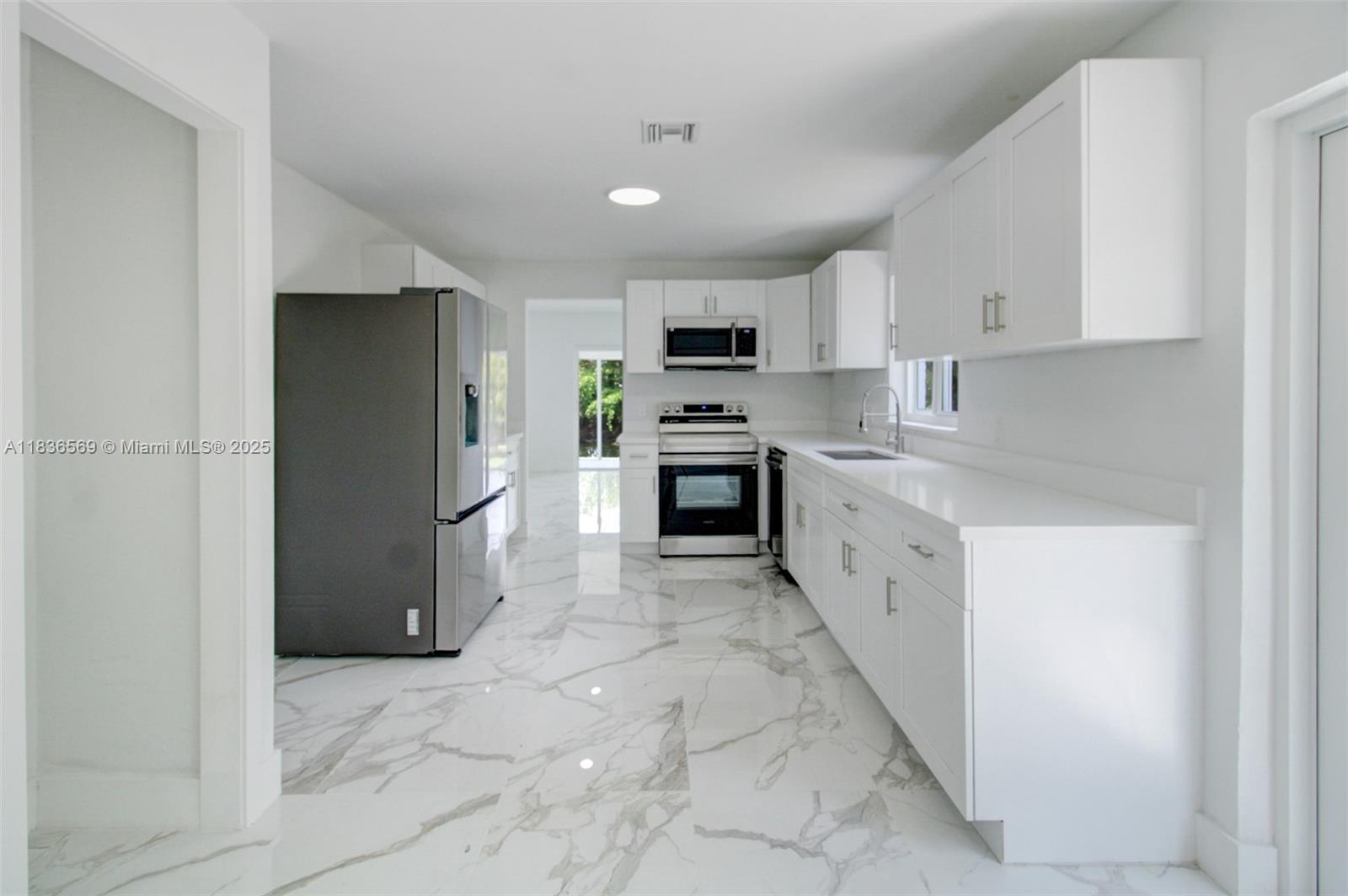 4808 Mango Drive Tamarac, FL 33319 - Photo 19 of 36 a kitchen with stainless steel appliances granite countertop a refrigerator a sink a stove top oven and white cabinets