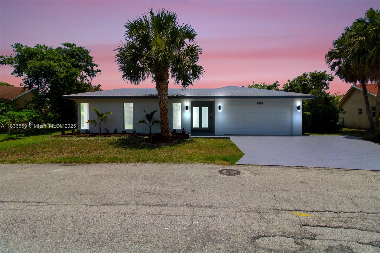 4808 Mango Drive Tamarac, FL 33319 - Photo 2 of 36 a front view of a house with a yard and potted plants