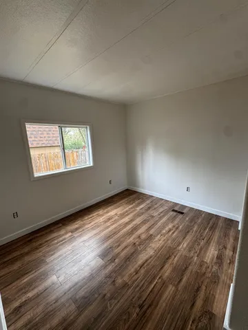 a view of a room with wooden floor and window